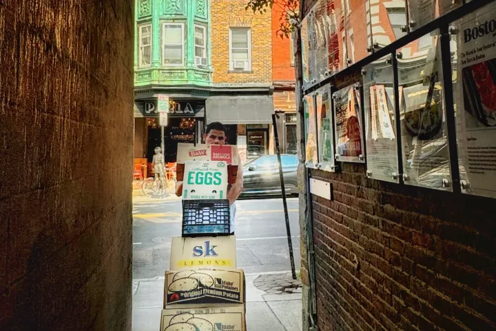 a sign on a sidewalk in front of a brick building