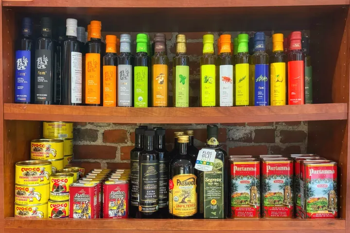 a bottle of wine next to a book shelf filled with books