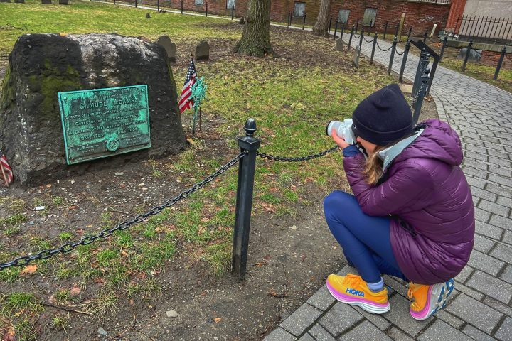 a person sitting on a bench next to a fence