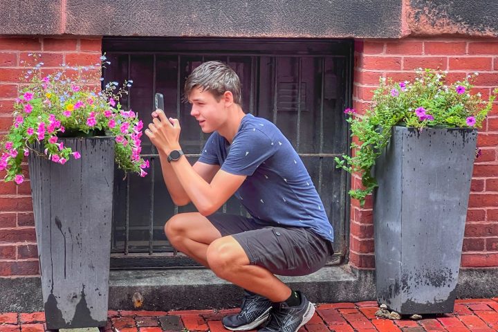 a person sitting in front of a brick building
