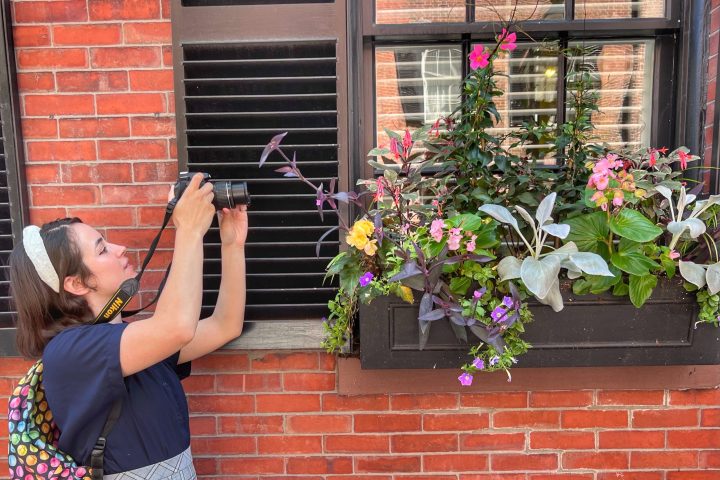 a woman standing in front of a brick building