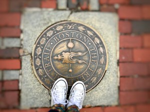 the freedom trail boston plaque on ground with person's shoes