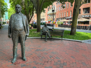 a statue of a person standing on a sidewalk